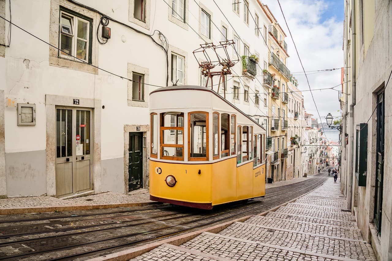 Yellow tram on a Lisbon hillside street — explore Portugal with an LTE.app eSIM